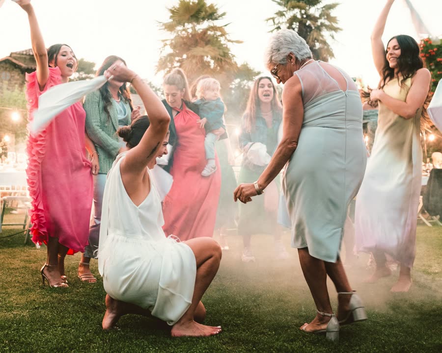 Mujeres bailando descalzas sobre el pasto en una celebración al aire libre