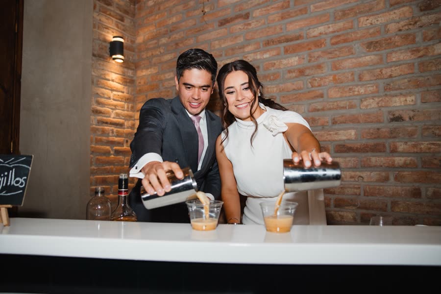 Una pareja de novios sirviendo café en la barra de su evento