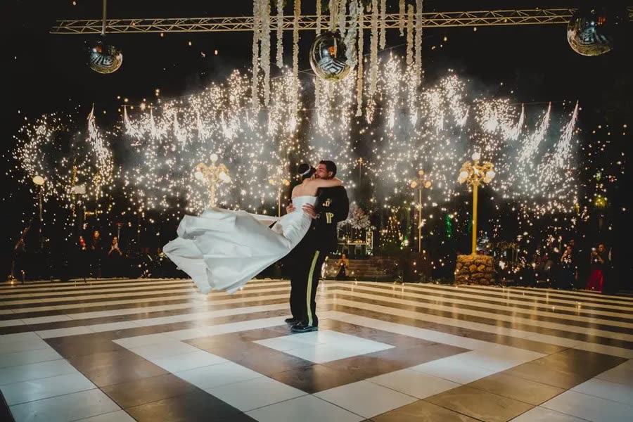 Primer baile de una pareja sobre una pista de cuadros, bajo una lluvia de chispas