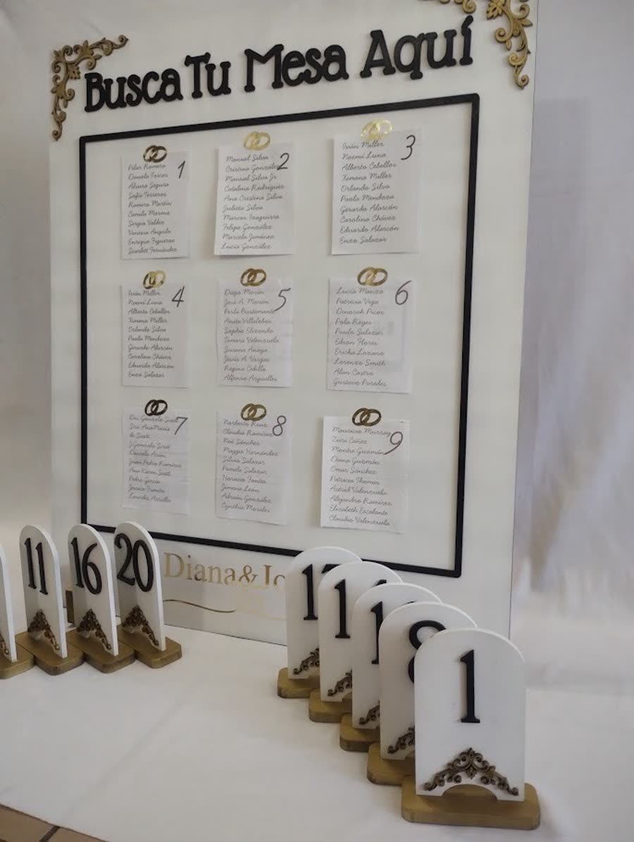 Tablero de acomodo de mesas y números tallados en madera para un banquete